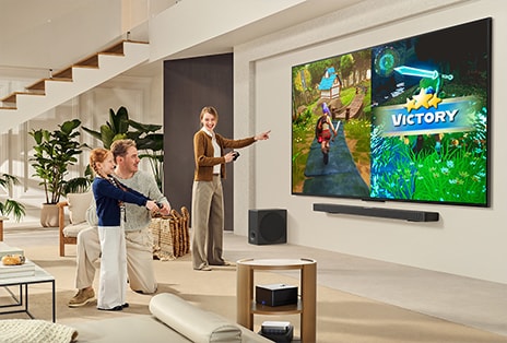 Familia de tres jugando en la sala con un televisor LG montado en la pared sobre una barra de sonido LG. La Zero Connect Box está dentro de una mesa de centro.