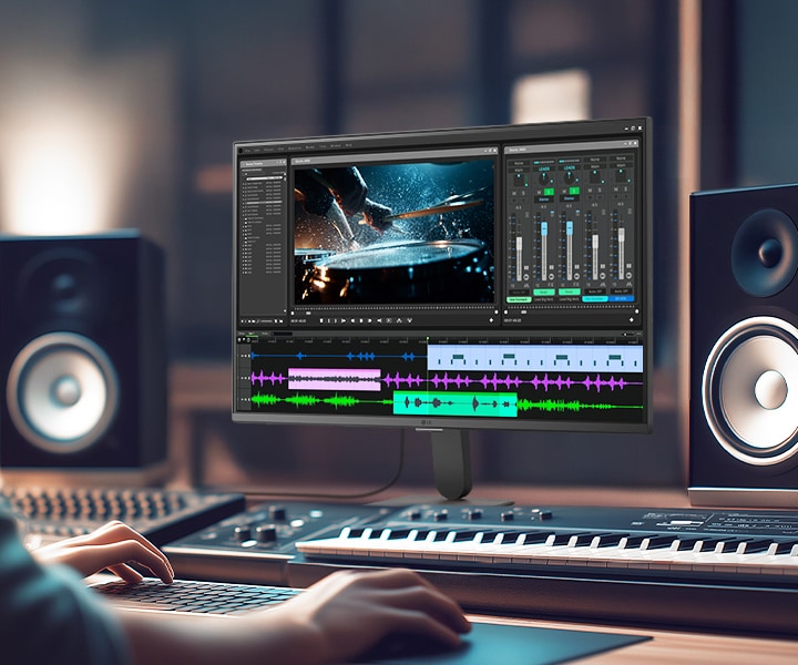 LG Smart Monitor displaying a professional video and audio editing workspace with timeline, color grading tools, and sound mixing interface, highlighting IPS 4K resolution, HDR support, and wide color coverage in a creative studio setup with speakers and keyboard for content production and multimedia work.