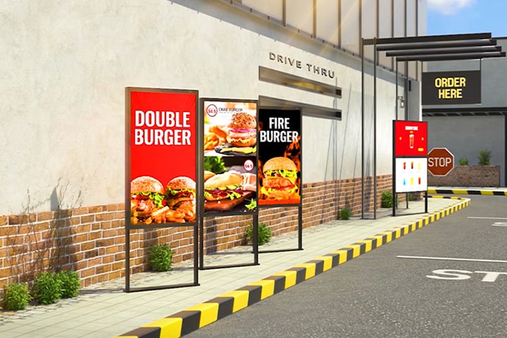 Hay cuatro XE3P instaladas en la zona de drive-trhu del lugar de hamburguesas, y están mostrando vívidamente el menú de hamburguesas e imágenes aún en el brillo del sol. 	
