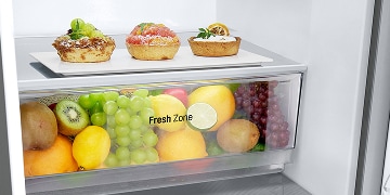 Interior de un refrigerador LG cuidadosamente abastecido con frutas, verduras, bebidas y postres, que muestra cómo la temperatura ideal conserva la frescura.