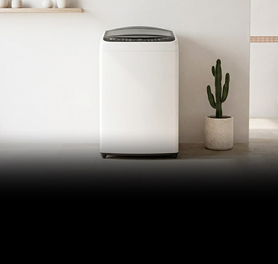 A white front-loading washing machine is placed between white-toned cabinets.