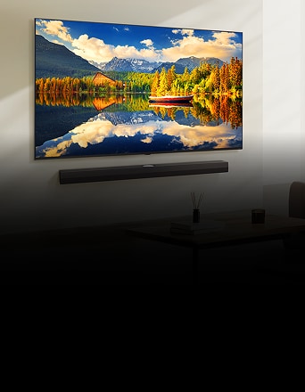 Televisor NanoCell montado en la pared que muestra una vista panorámica y luminosa de un lago con montañas y un bote rojo.