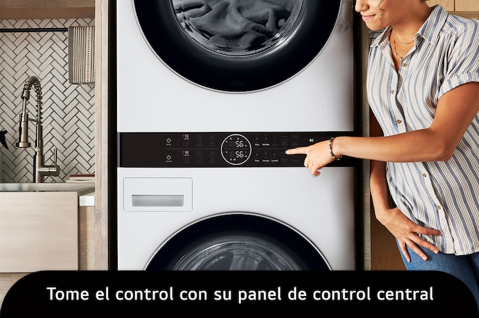 La LG WashTower® WK22WS6E en color blanco, mostrando a una usuaria accediendo fácilmente al panel de control central. Lavadora de 22 kg, Secadora de 22 kg.