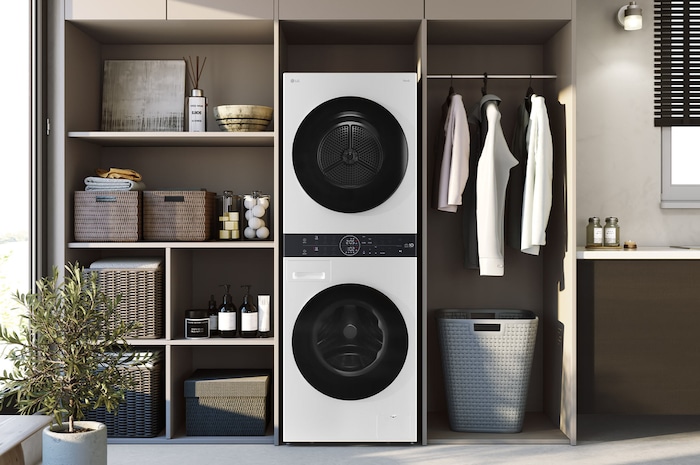 WashTower LG WK14WS6 Blanco, integrado elegantemente en un cuarto de lavado moderno con estanterías de madera y gabinetes neutros.