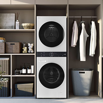 WashTower LG WK14WS6 Blanco, integrado elegantemente en un cuarto de lavado moderno con estanterías de madera y gabinetes neutros.