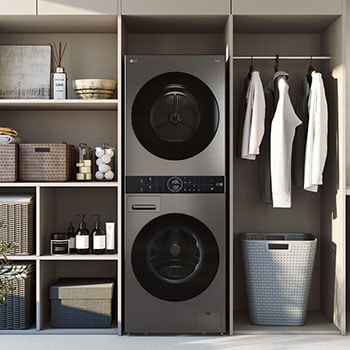 Imagen de estilo de vida del electrodoméstico LG WashTower™ negro centrado en un cuarto de lavado moderno y luminoso, con estanterías, una encimera y una ventana al fondo.