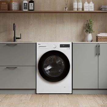 Lavadora de Carga Frontal LG WM20EWNTS6PGrafito Esencia, integrada en un moderno cuarto de lavado con gabinetes gris-beige y encimeras de madera.