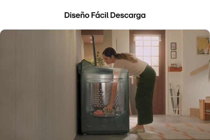 Una mujer descargando ropa fácilmente de la lavadora LG WT25EWTX6, gracias al diseño ergonómico de la tina (Diseño Fácil Descarga).