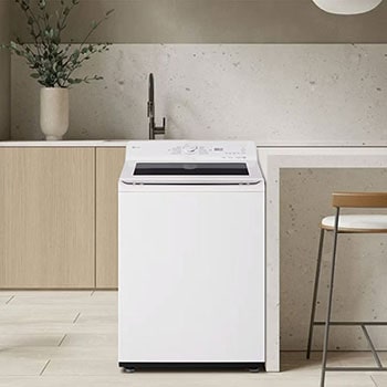 La lavadora de carga superior LG WT25EWTX6 de 25 kg en color blanco con panel de control negro, instalada en una moderna cocina o cuarto de lavado.