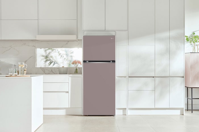 Refrigerador Top-Freezer LG VT40BJP Color Rosa Arcilla, integrado en una cocina moderna y luminosa con gabinetes blancos, destacando su elegante diseño a color.