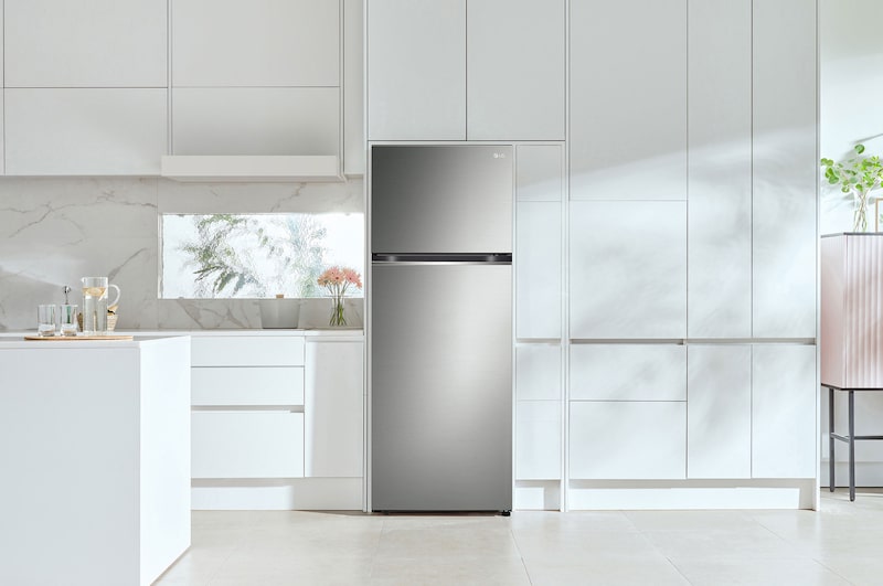 Refrigerador Top-Freezer LG VT45BP Platino, integrado elegantemente en una cocina moderna y minimalista con gabinetes blancos.