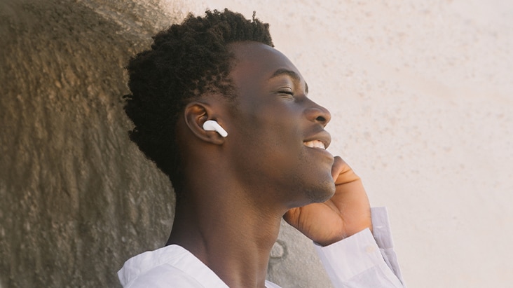   Un hombre lleva audífonos T90 y escucha música con los ojos cerrados.
