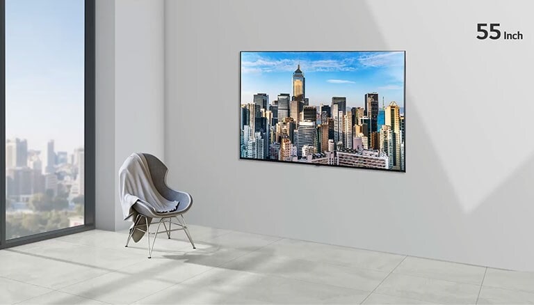 Un televisor de pantalla plana montado en una pared gris junto a una ventana del piso al techo y una silla. La pantalla muestra un paisaje urbano contra un cielo azul y el tamaño del televisor aumenta de 55 a 86 pulgadas.