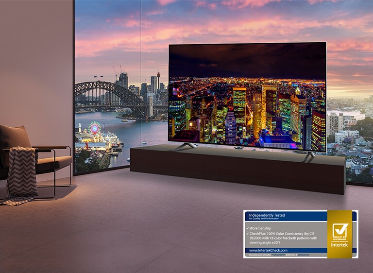 Habitación con vistas al río y al paisaje urbano. Un televisor está instalado frente a la ventana que muestra una vista nocturna del horizonte de la ciudad contra un cielo oscuro.