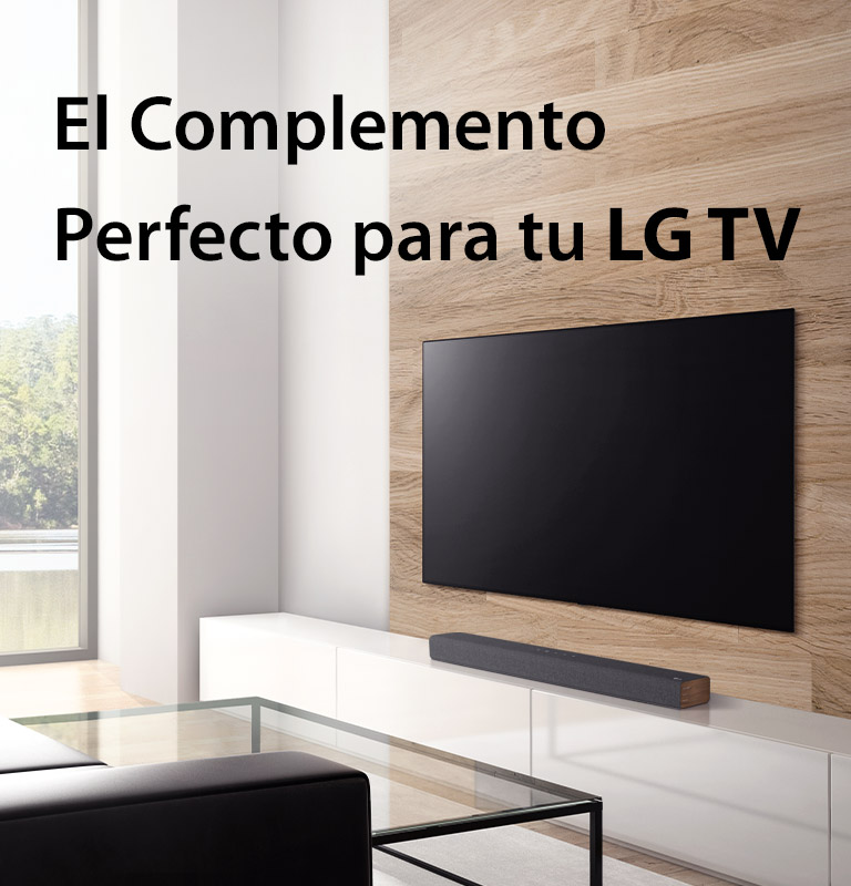 Se coloca una barra de sonido en un mueble de televisión blanco y el televisor se coloca en una pared de madera. Hay una vista del bosque fuera de la ventana. El texto está escrito en la imagen: la mejor combinación con televisores LG.