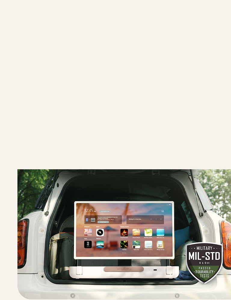 Vista frontal de LG StandbyME Go. El producto está colocado en un carro, la pantalla de rota horizontalmente, mostrando el menú de inicio. En la izquierda inferior de la imagen, se muestra el icono de especificación militar.