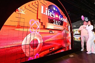 Visitantes observando la pantalla LED curva en un evento de tecnología (CES)