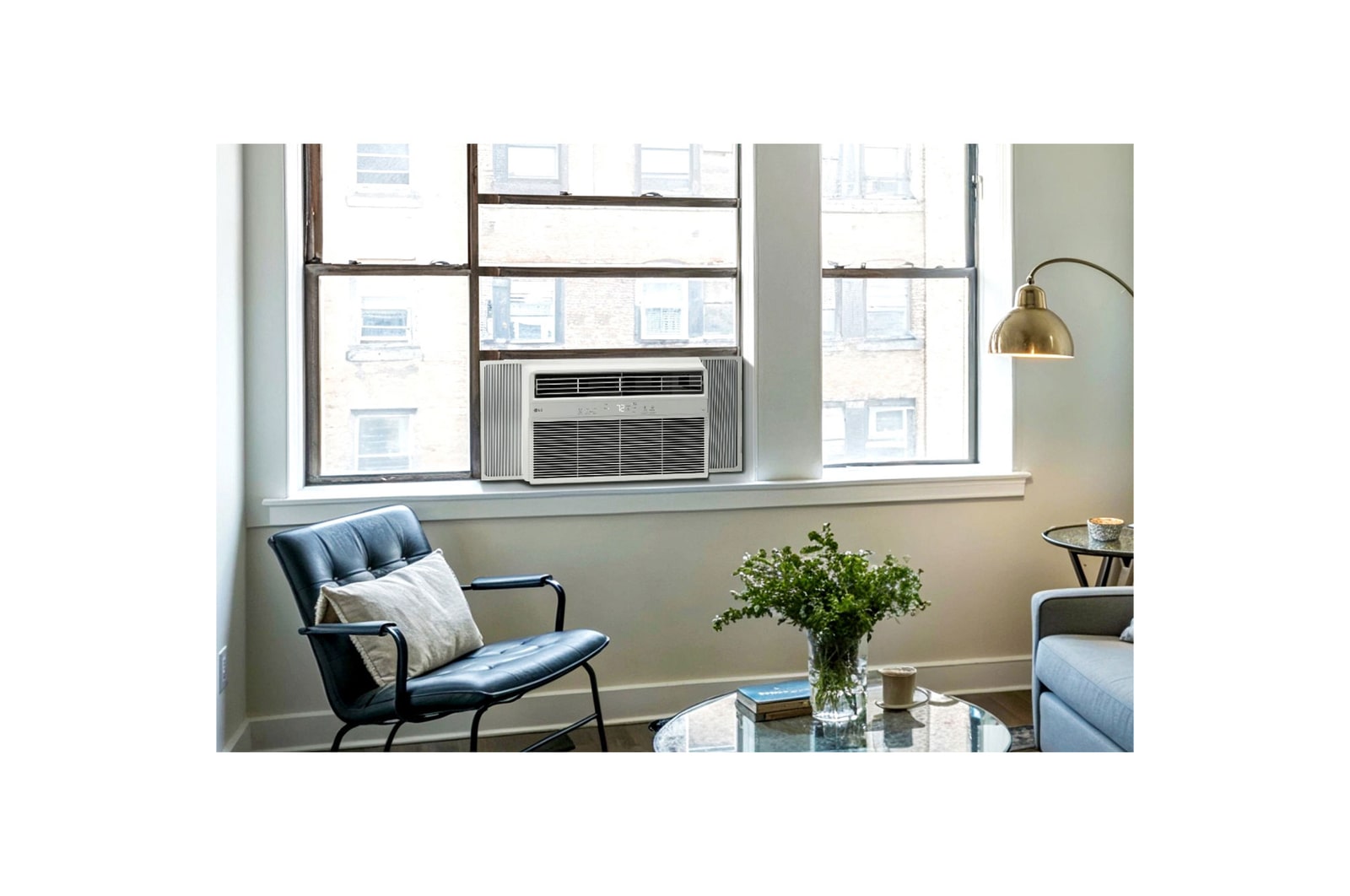 Window air conditioner installed in a living room with a sofa and plants