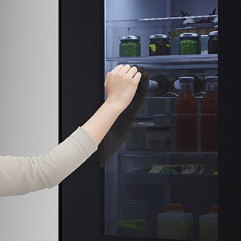 Alguien tocando dos veces en la función InstaView™ del refrigerador LG Side by Side.