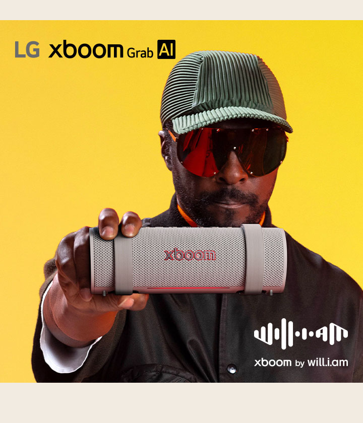 will.i.am, con traje negro y gafas de sol, sostiene el xboom Grab al frente.