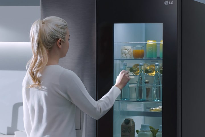 Mostrando a alguien usando la función InstaView™ del refrigerador LG Side by Side.
