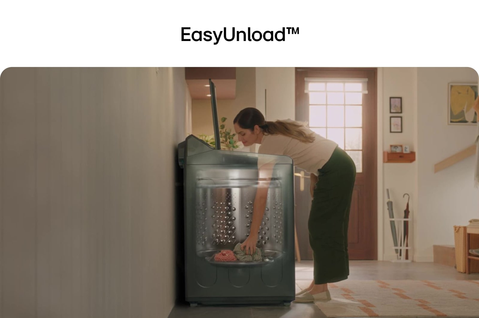 Woman unloading laundry from a top loading washing machine, featuring EasyUnload™.