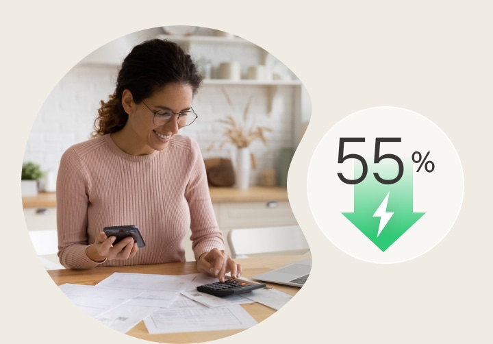 Una mujer revisando una factura con el icono de la flecha de ahorro energético del 55%.