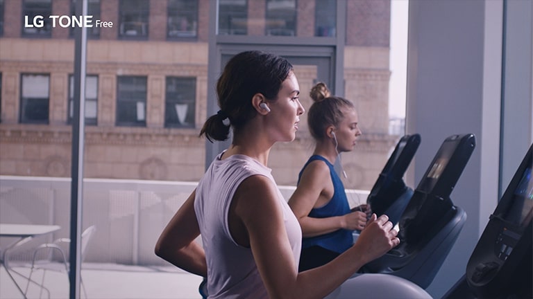 An image of a woman running on a treadmill wearing tone free.