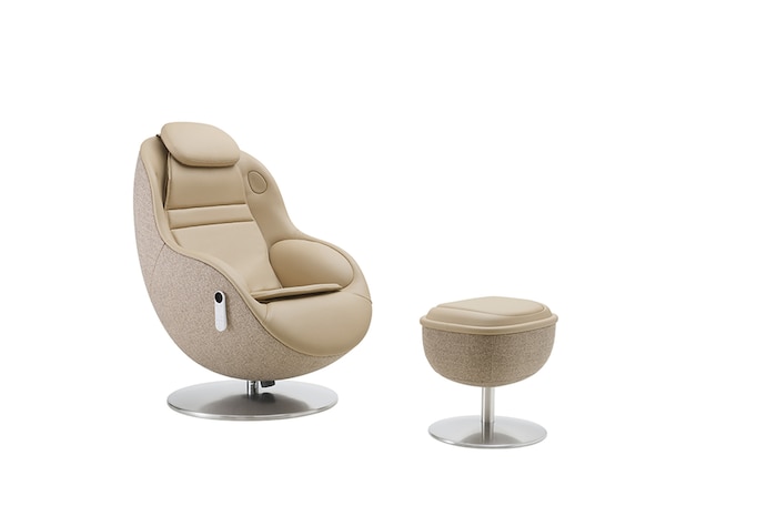 Angled white massage chair and footstool highlighting its curved silhouette on a neutral backdrop.