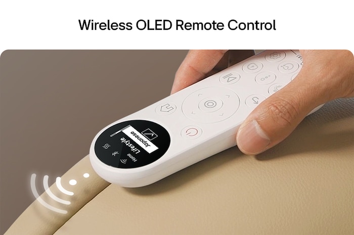 White OLED remote with circular buttons magnetically attached to a beige armrest, display visible at a glance.