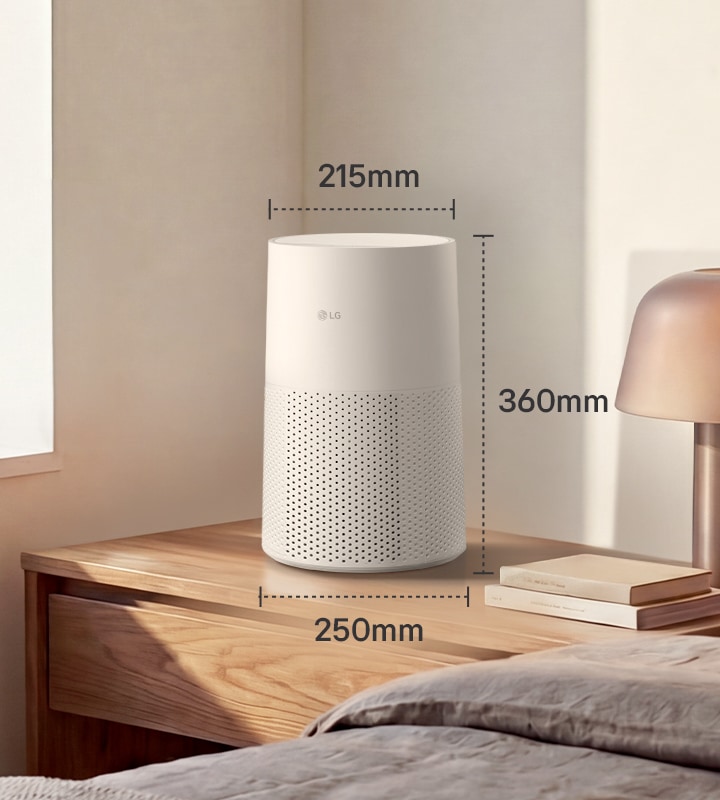 A white LG air purifier on a bedside table with dimensions: 215mm wide, 360mm high, and 250mm deep, shown in a bright bedroom setting