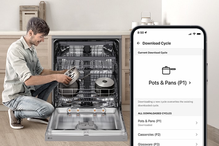 A woman is setting cleaning cycle preferences using the LG ThinQ app in the kitchen.