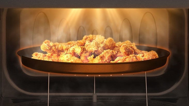 Crispy chicken is being cooked by neochef microwave oven.	