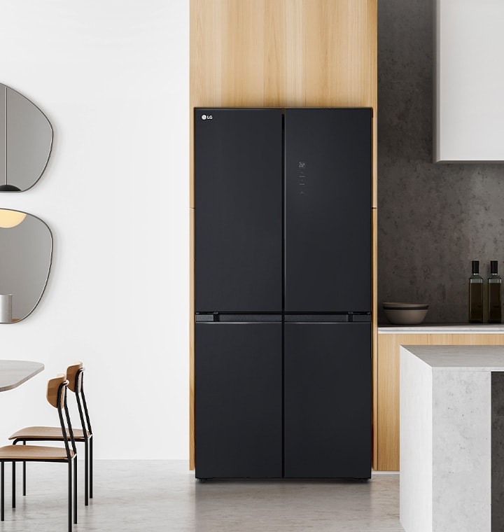 Modern kitchen with lg multi-door refrigerator in a sleek, black finish, accompanied by a round dining table with wooden chairs, including abstract mirrors and minimalist furnishings.