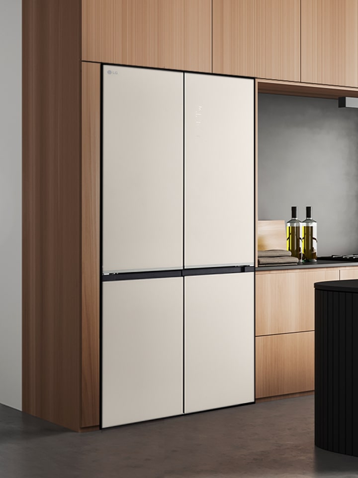 Modern kitchen interior with a black built-in refrigerator, wood cabinets, and a kitchen island with stools.