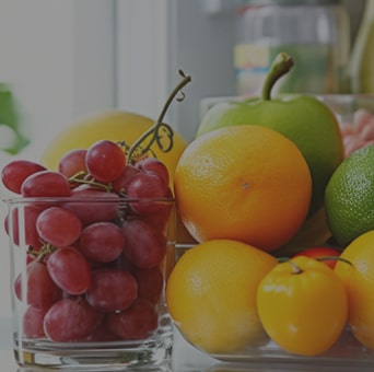 Close up view of an lg multi door refrigerator with various fresh fruits and vegetables.