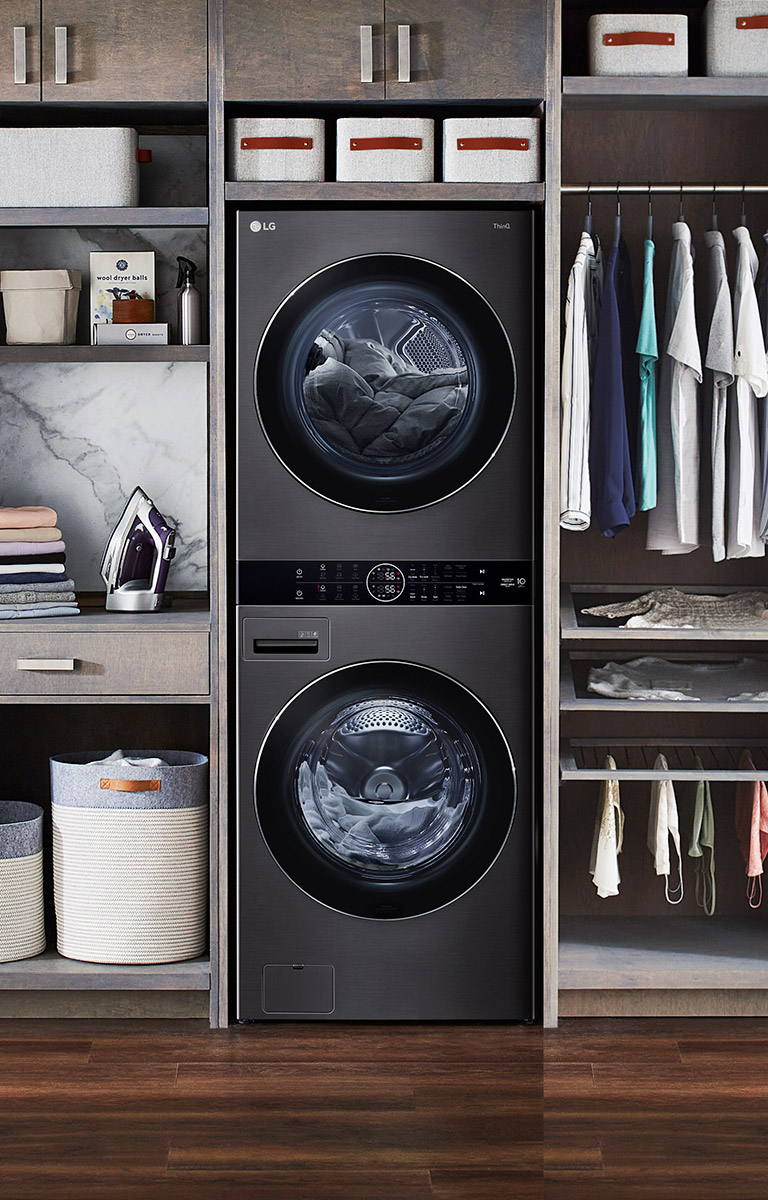A black LG Wash Tower is installed with shelving and a closet in a wall unit.
