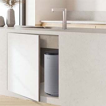 A water purifier partially visible through a slightly open under-sink cabinet	