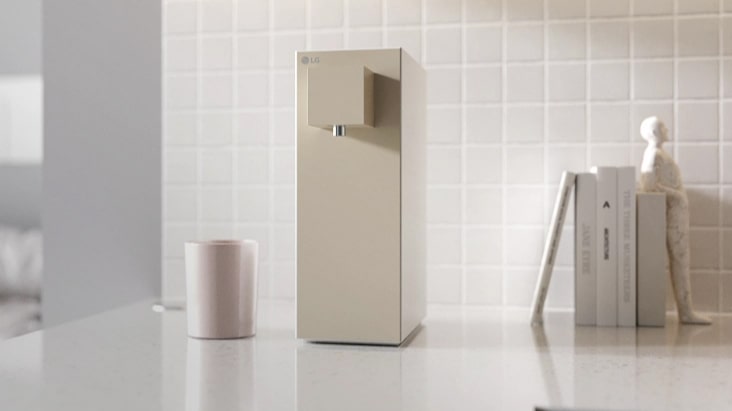 LG water purifier placed between cups and books.