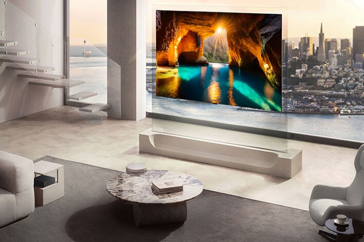 LG OLED evo AI W6 Wallpaper TV with a 9mm-range profile stands before floor-to-ceiling windows overlooking a city and river, displaying a Vincent van Gogh painting that enriches depth while maintaining a refined interior.