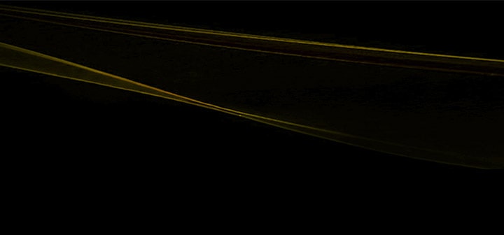 LG TV as a cinema TV is visualized as abstract gold wave-like lines on a black background, extending horizontally with smooth curves and gradient tones to form a continuous flowing pattern.
