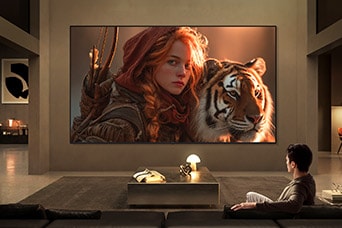 LG TV for watching movies fills a modern living room with a cinematic scene on a large wall-mounted display, featuring a detailed close-up of a character and tiger, highlighting rich color depth, strong contrast, and immersive viewing.