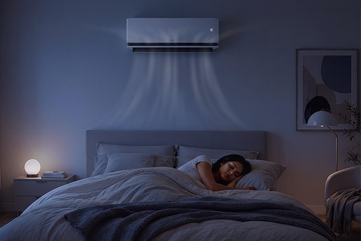 Woman sleeping under an LG DUALCOOL AI Air in a bedroom