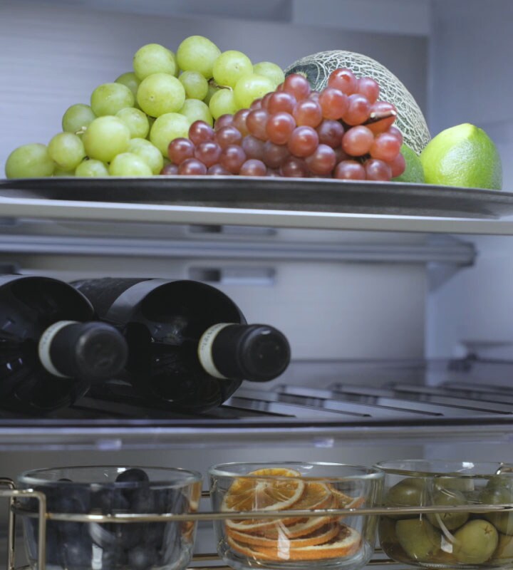 LG koelkast met vriesvak (GBBS322CEV) binnenaanzicht met fruit op de wijnflessen van de bovenste plank in het midden en meer fruit op de onderste plank