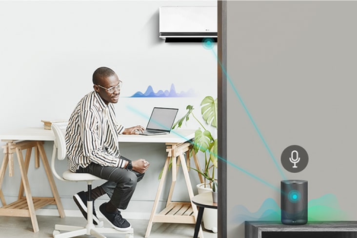 Man in thuiskantoor met LG airconditioner verbonden met een AI-luidspreker voor spraakbediening.