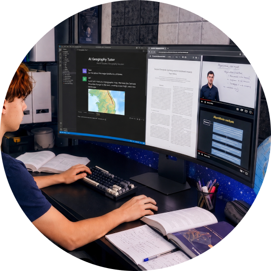 Een student zit aan een bureau te studeren terwijl hij kijkt naar een wetenschappelijk artikel en online colleges op een grote, brede monitor.