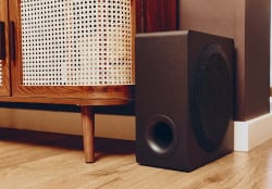 Draadloze subwoofer naast een houten kast in de woonkamer