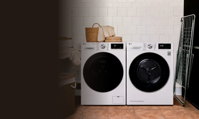 Een witte LG wasmachine en droger naast elkaar in een betegelde wasruimte, met een mand en handdoeken op de wasmachine en een droogrek ernaast.