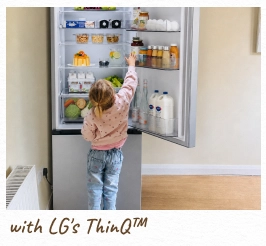 Een peutertje reikt in een open, verlichte koelkast. [met LG ThinQ™]