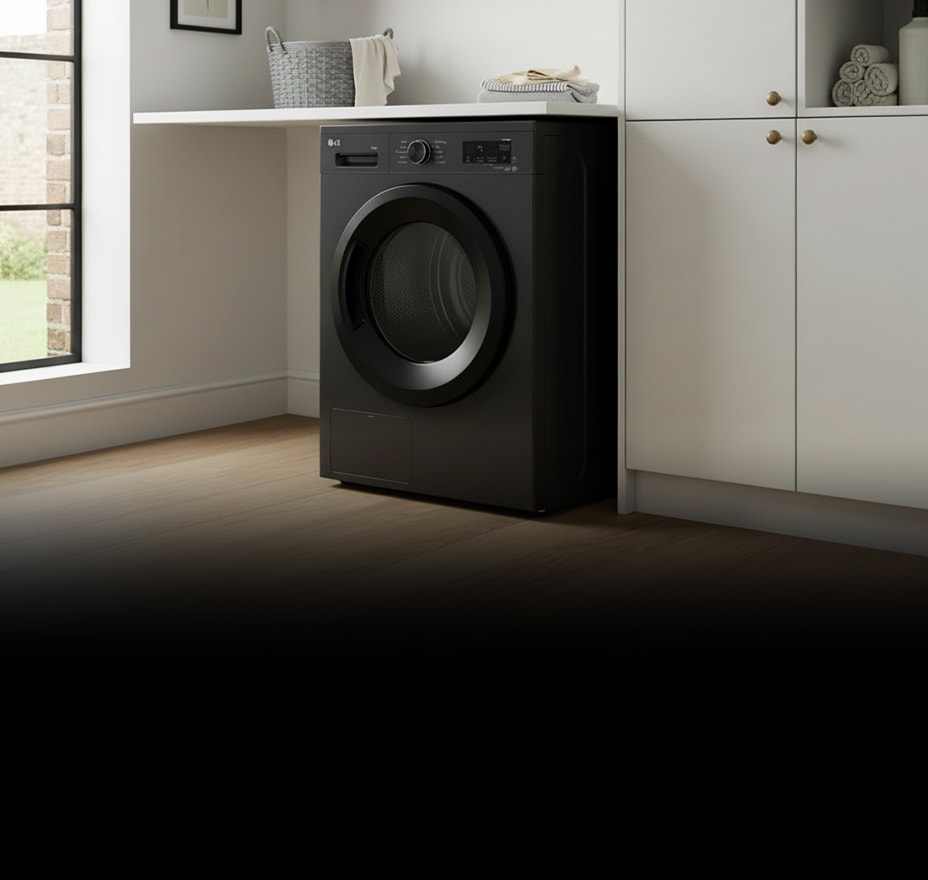 A black front-loading dryer is installed beneath white cabinetry in a bright laundry space.